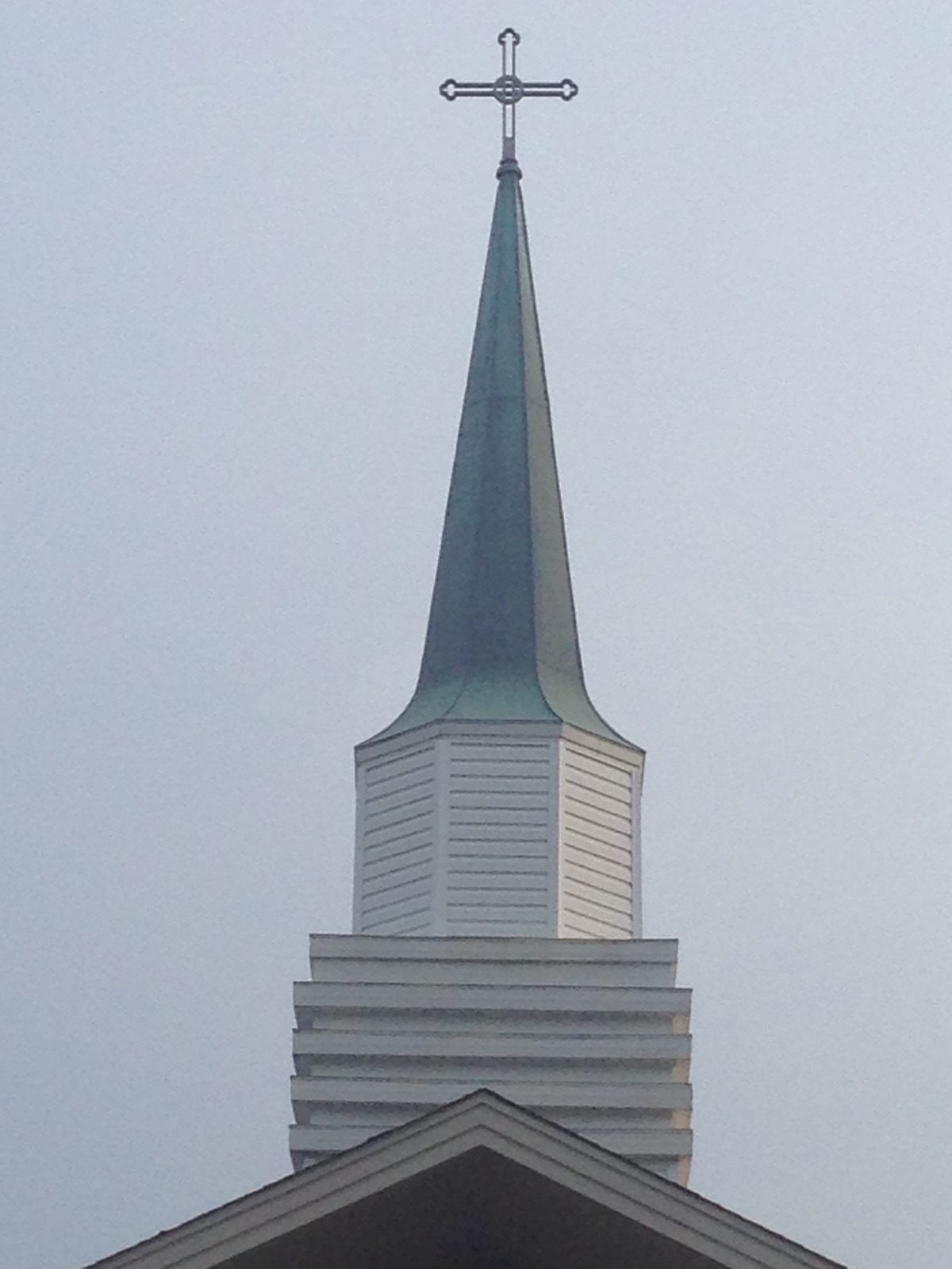 The steeple and cross of Norris Hill Presbyterian Church against the sky